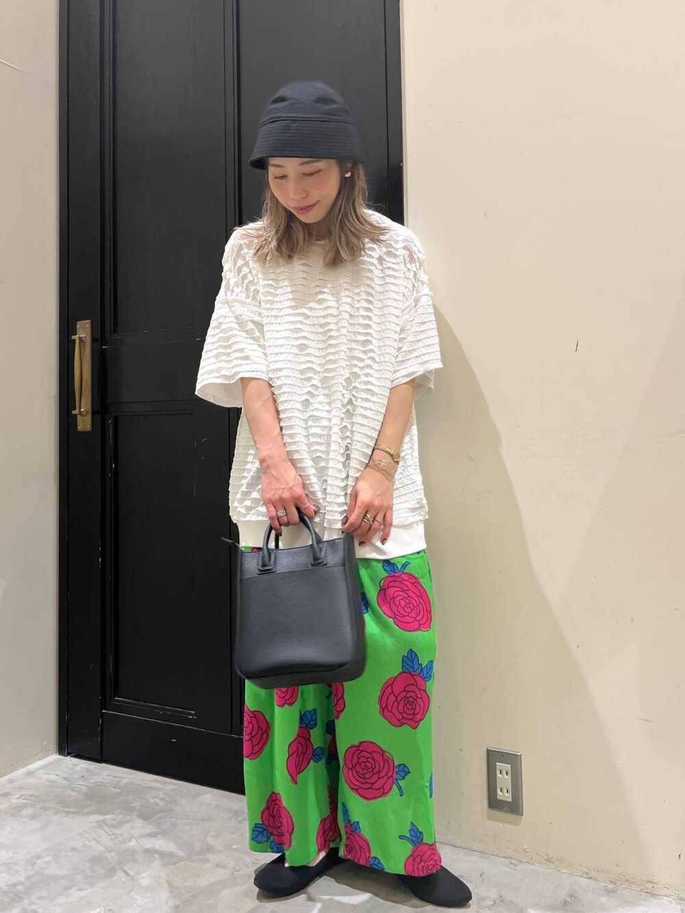 ブラック系のトートバッグ、ブラック系のパンプス、ホワイト系のTシャツ/カットソーを着用したレディースの春コーディネートの2枚目の写真