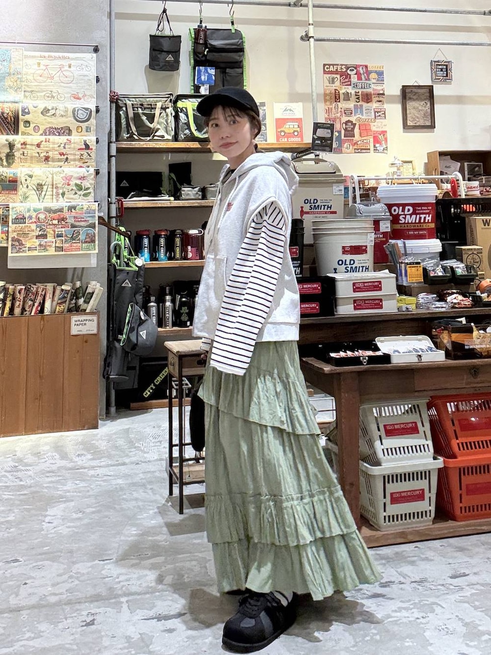 ブラック系のショルダーバッグ、ホワイト系のTシャツ/カットソー、グレー系のベストを着用したレディースの春コーディネートの7枚目の写真