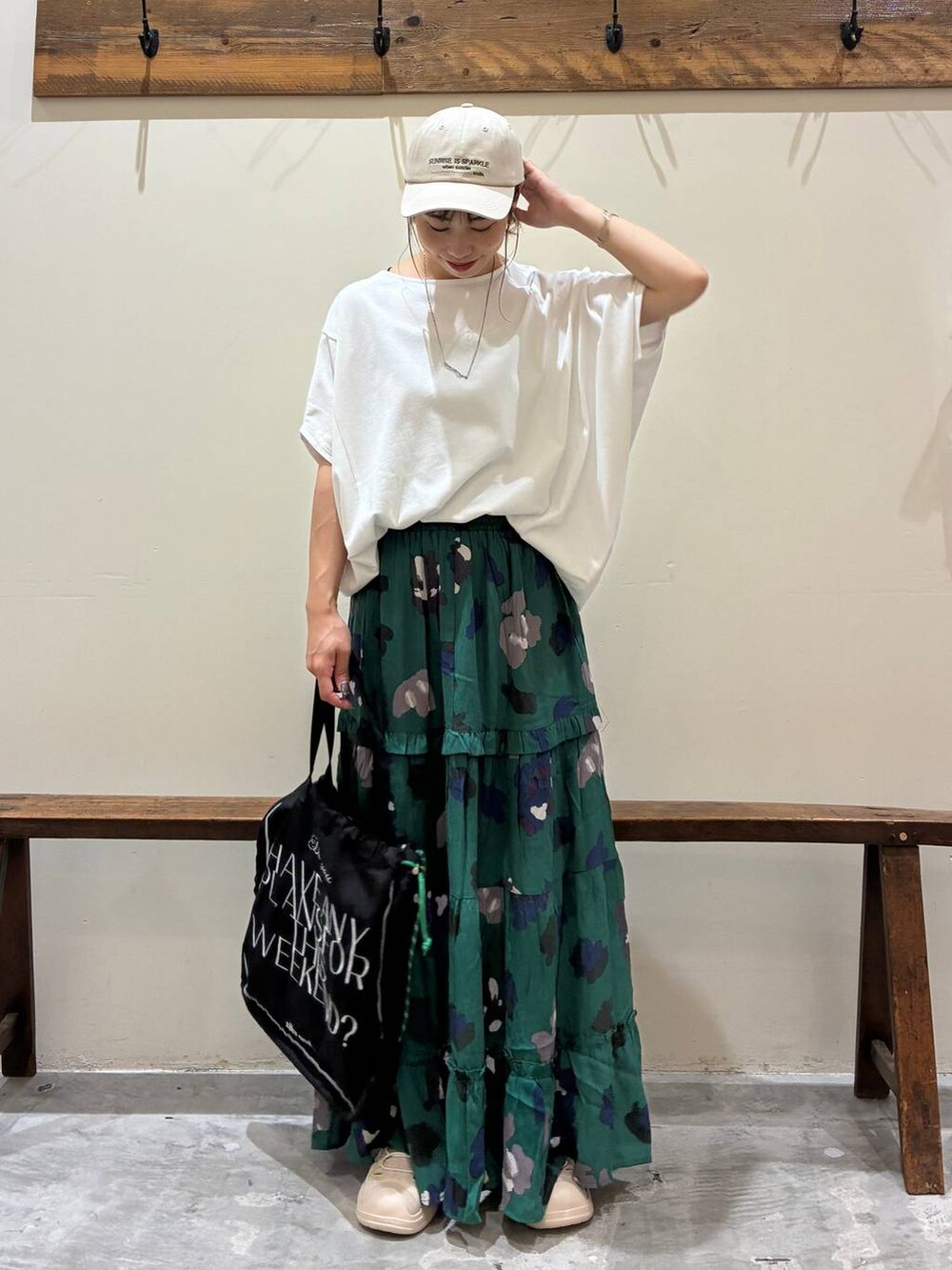 ブラック系のトートバッグ、グリーン系のスカート、ベージュ系のサンダルを着用したレディースの夏コーディネートの3枚目の写真