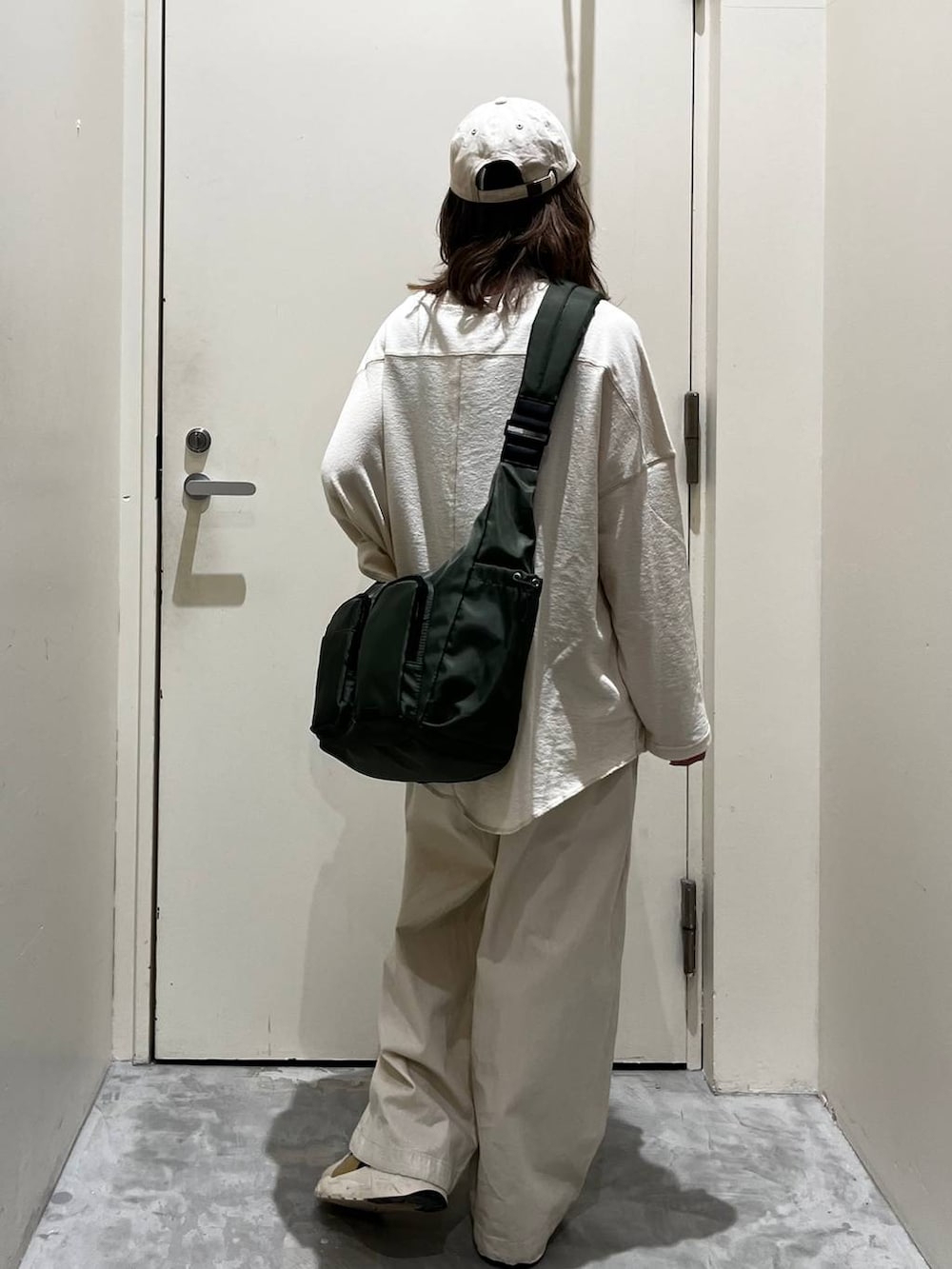 ベージュ系のその他パンツ、ベージュ系のTシャツ/カットソー、グリーン系のショルダーバッグを着用したレディースの冬コーディネートの2枚目の写真