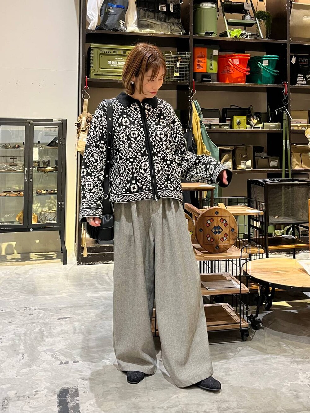 グレー系のその他パンツ、ベージュ系のTシャツ/カットソー、ブラック系のブーツを着用したレディースの冬コーディネートの5枚目の写真
