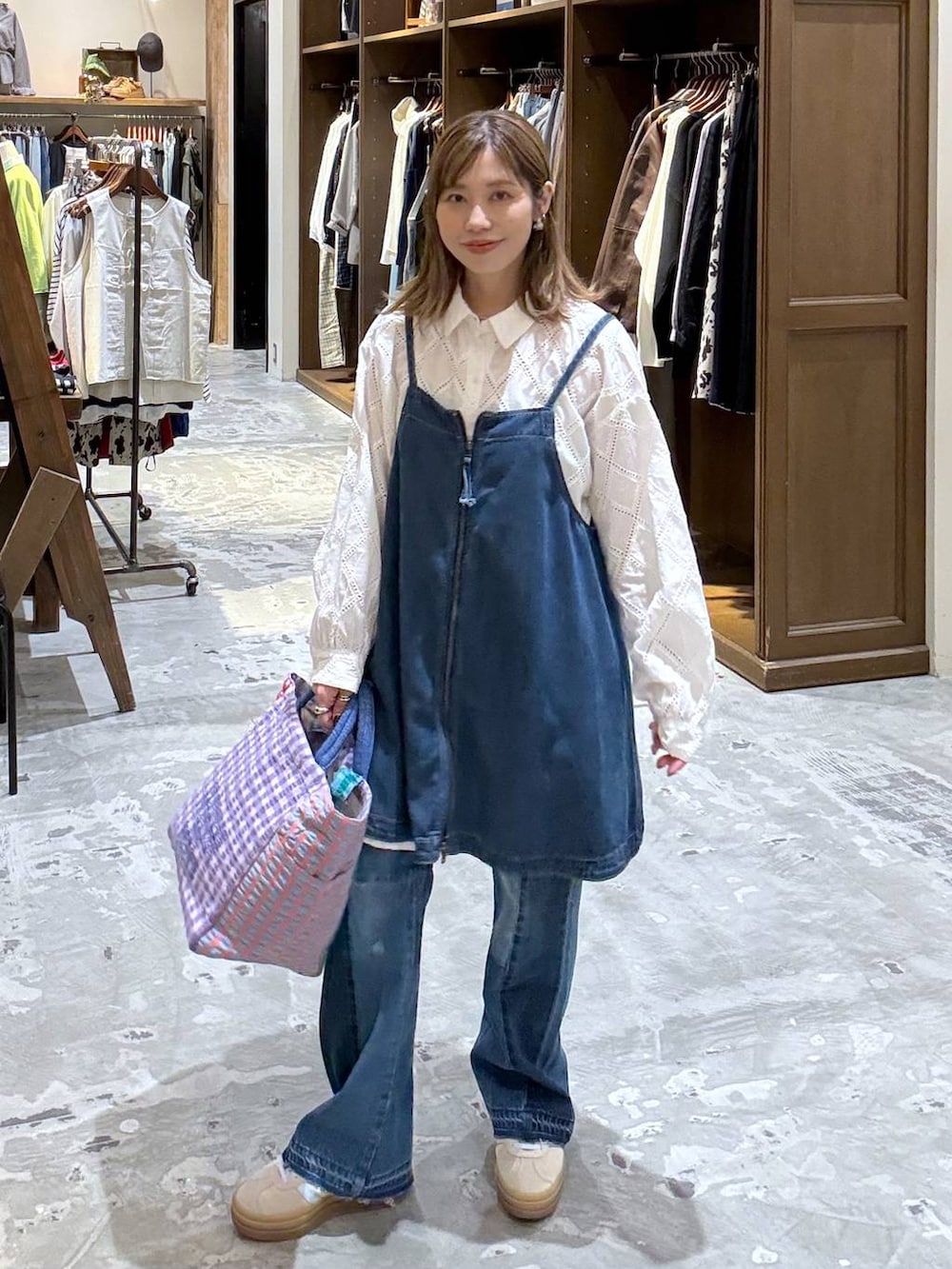 ベージュ系のスニーカー、ブルー系のデニムパンツ、ブルー系のキャミソールを着用したレディースの春コーディネートの2枚目の写真