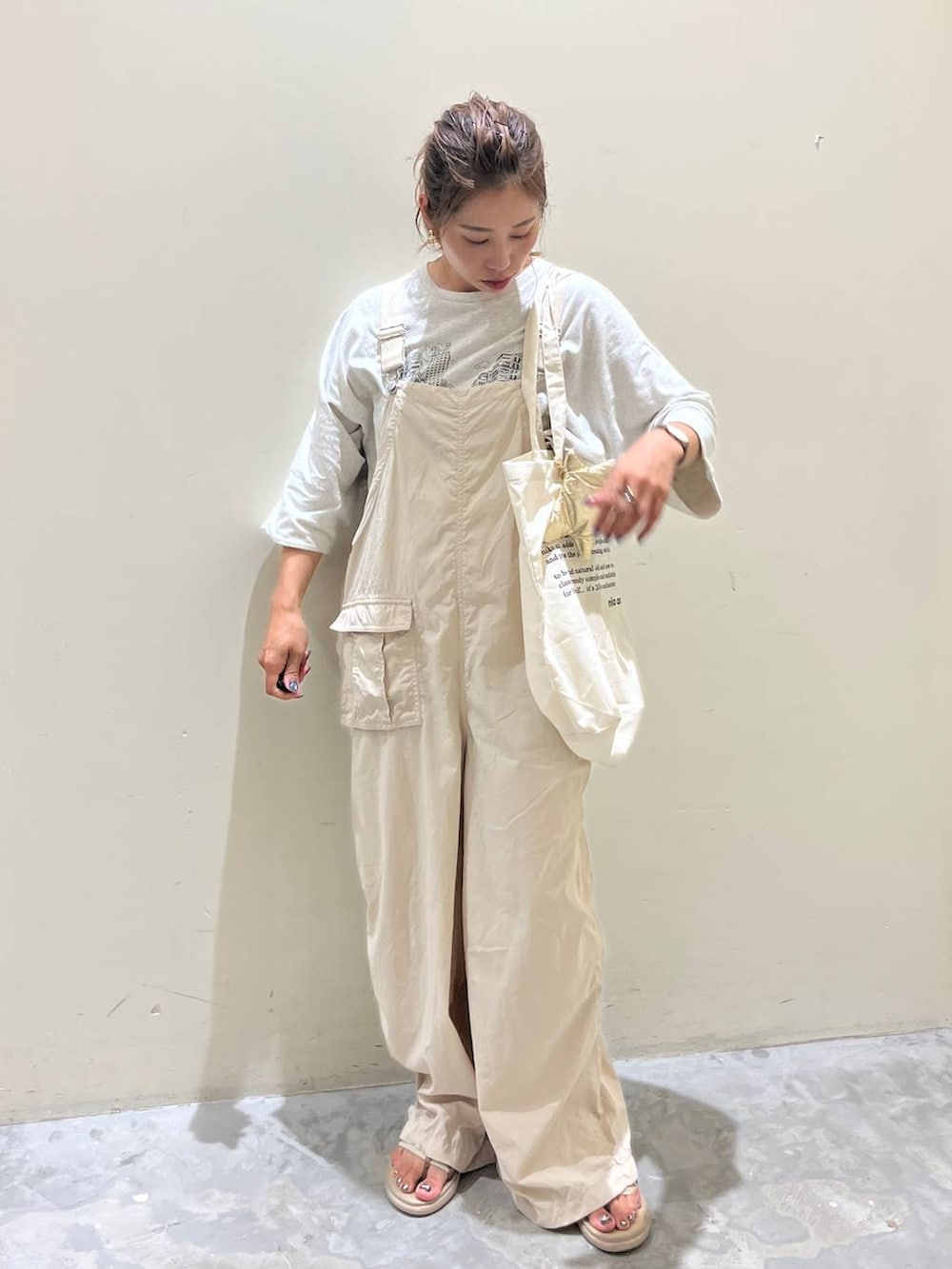 ベージュ系のサロペット/オーバーオール、ベージュ系のTシャツ/カットソー、ベージュ系のサンダルを着用したレディースの夏コーディネートの5枚目の写真