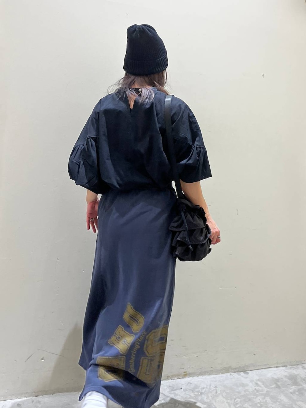 ブラック系のショルダーバッグ、ブルー系のスカート、ブラック系のシャツ/ブラウスを着用したレディースの春コーディネートの4枚目の写真