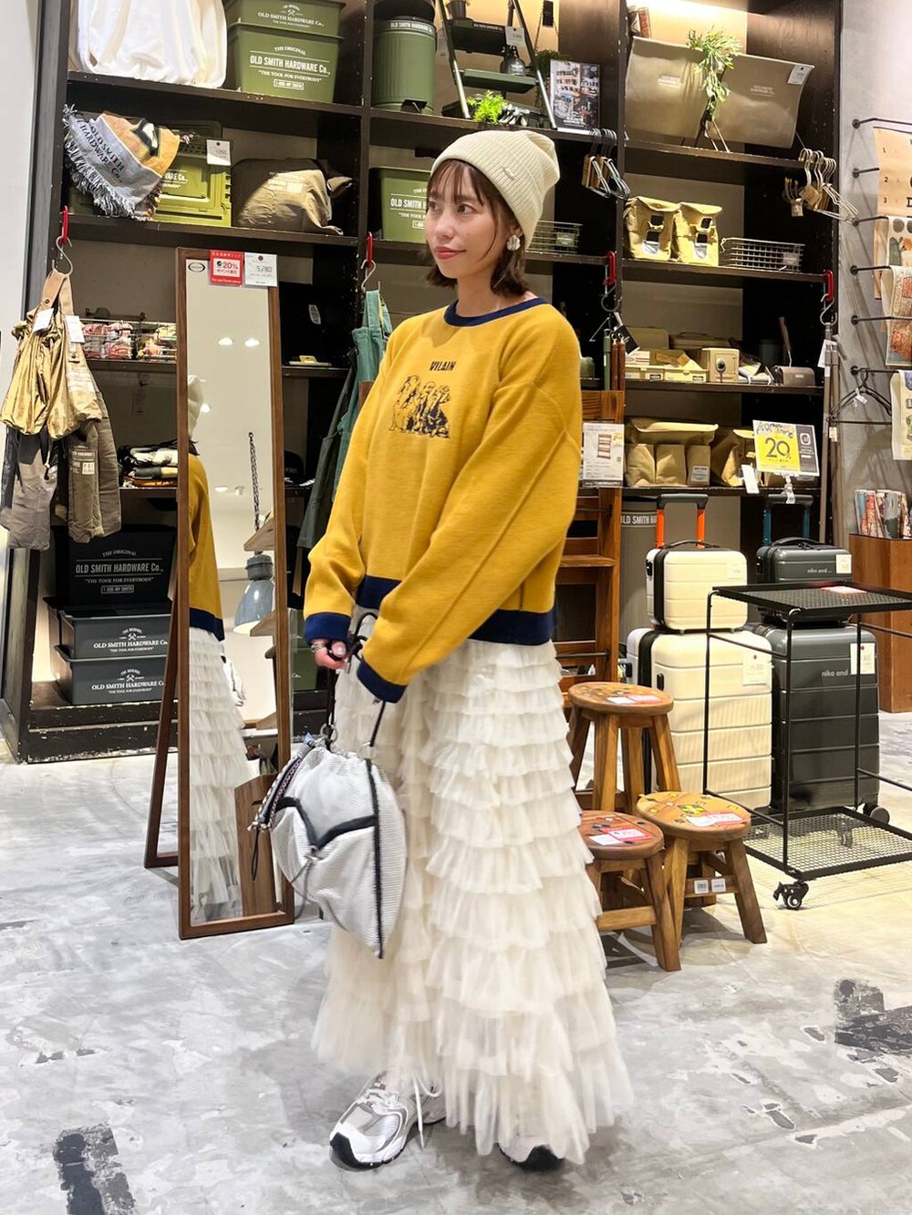 ホワイト系のスニーカー、グレー系のショルダーバッグ、ホワイト系のスカートを着用したレディースの秋コーディネートの7枚目の写真