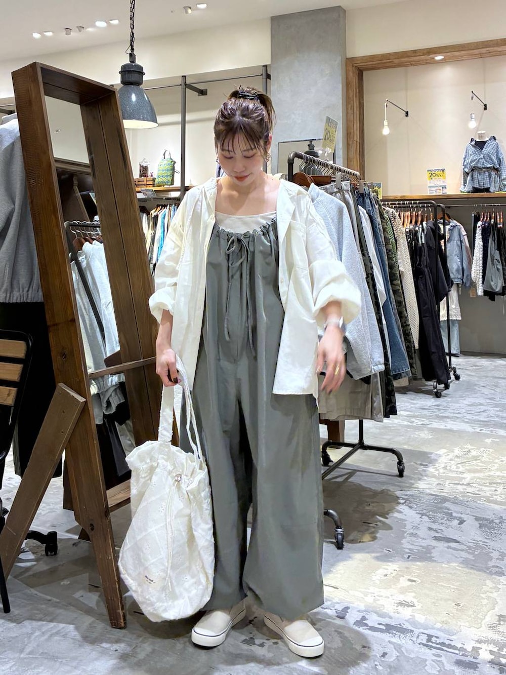 グリーン系のサロペット/オーバーオール、ホワイト系のシャツ/ブラウス、ベージュ系のタンクトップを着用したレディースの春コーディネートの3枚目の写真