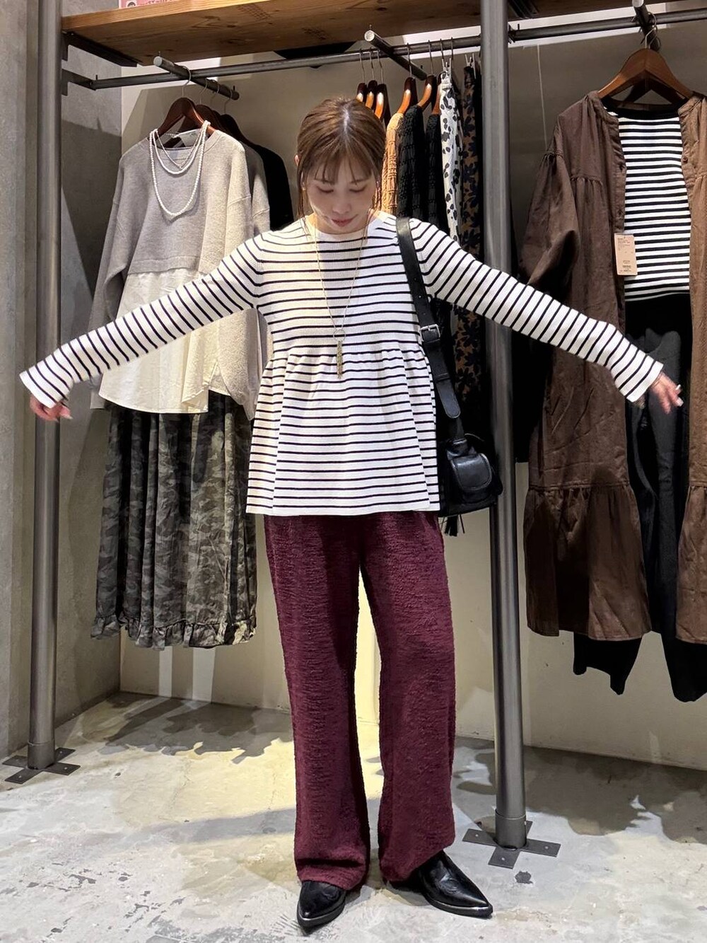 ベージュ系のニット/セーター、ブラック系のその他シューズ、レッド系のその他パンツを着用したレディースの秋コーディネートの4枚目の写真