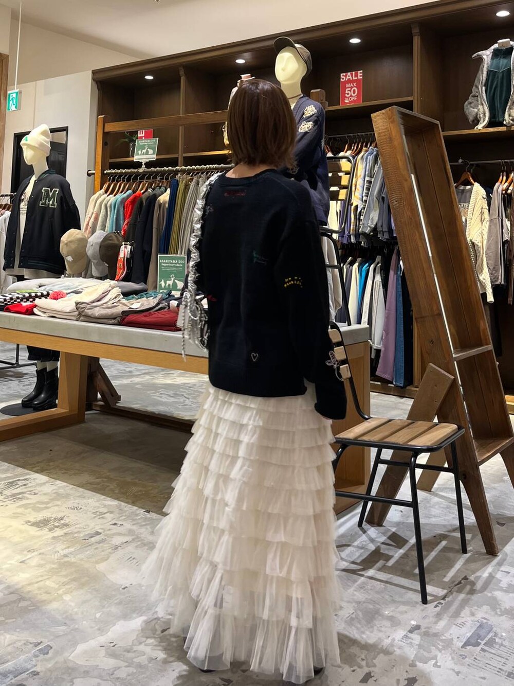 グレー系のブーツ、ホワイト系のスカート、シルバー系のショルダーバッグを着用したレディースの冬コーディネートの5枚目の写真