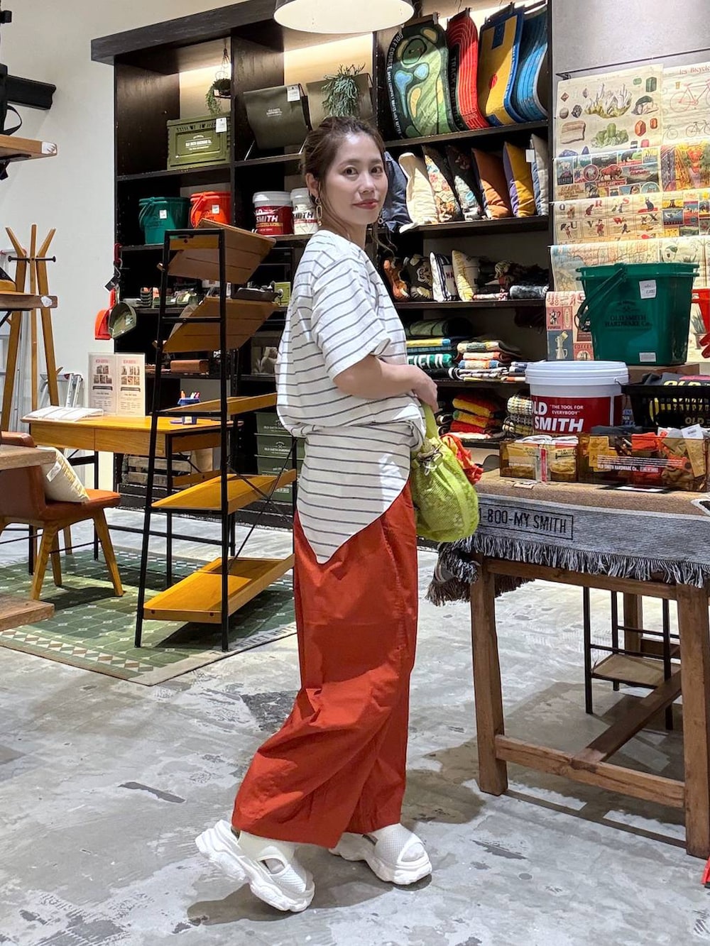 オレンジ系のその他パンツ、オレンジ系のTシャツ/カットソー、イエロー系のショルダーバッグを着用したレディースの春コーディネートの7枚目の写真