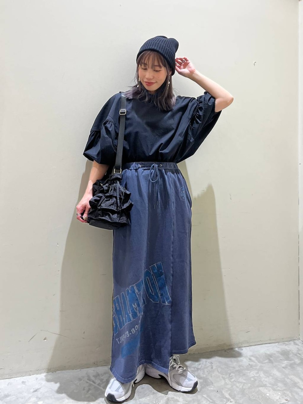 ブラック系のショルダーバッグ、ブルー系のスカート、ブラック系のシャツ/ブラウスを着用したレディースの春コーディネートの2枚目の写真