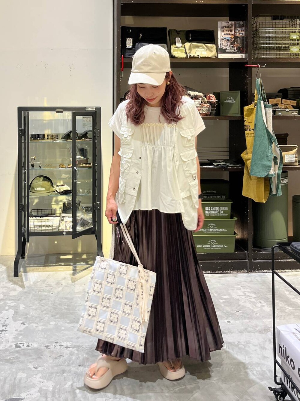 ベージュ系のサンダル、ベージュ系のスカート、ベージュ系のベストを着用したレディースの夏コーディネートの6枚目の写真