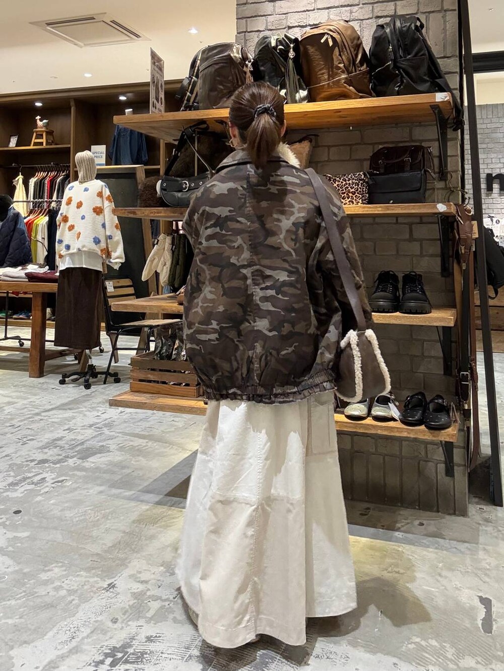 ゴールド系のスニーカー、ブラウン系のショルダーバッグ、レッド系のニット/セーターを着用したレディースの秋コーディネートの3枚目の写真