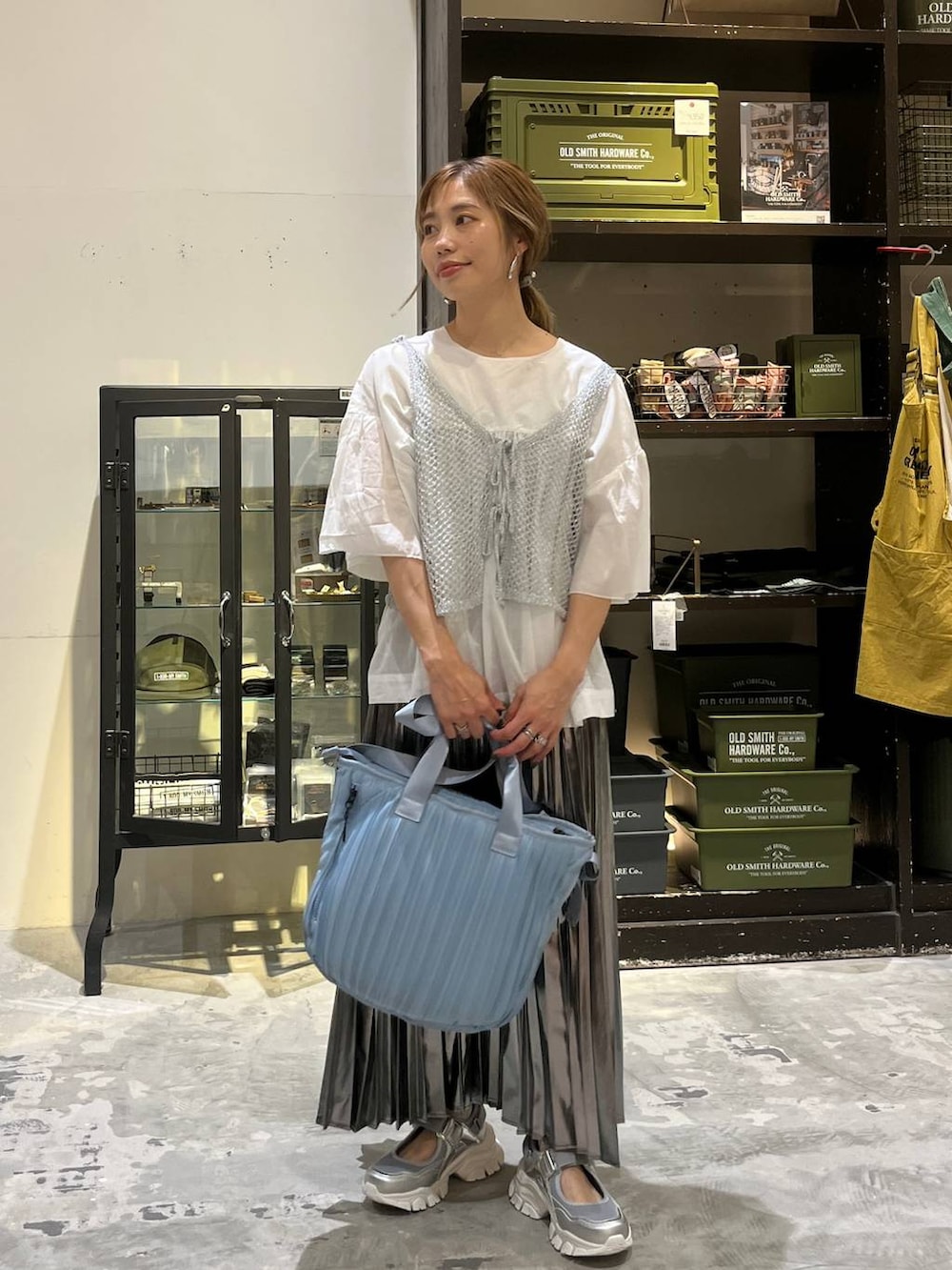 グレー系のスカート、ブルー系のトートバッグ、シルバー系のスニーカーを着用したレディースの夏コーディネートの8枚目の写真