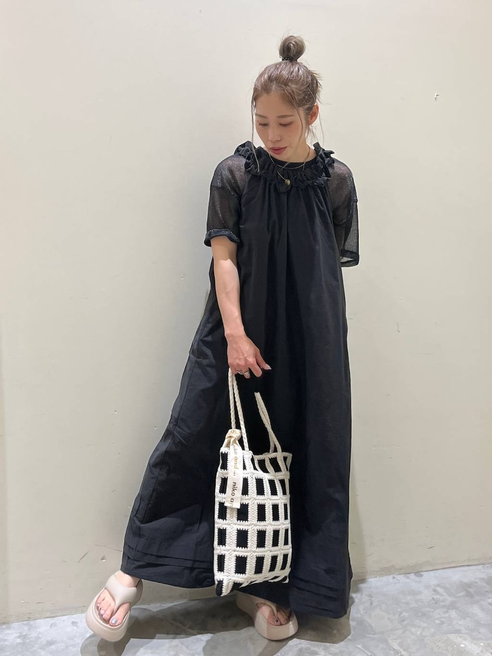 ベージュ系のサンダル、ブラック系のワンピース、ブラック系のトートバッグを着用したレディースの春コーディネートの2枚目の写真