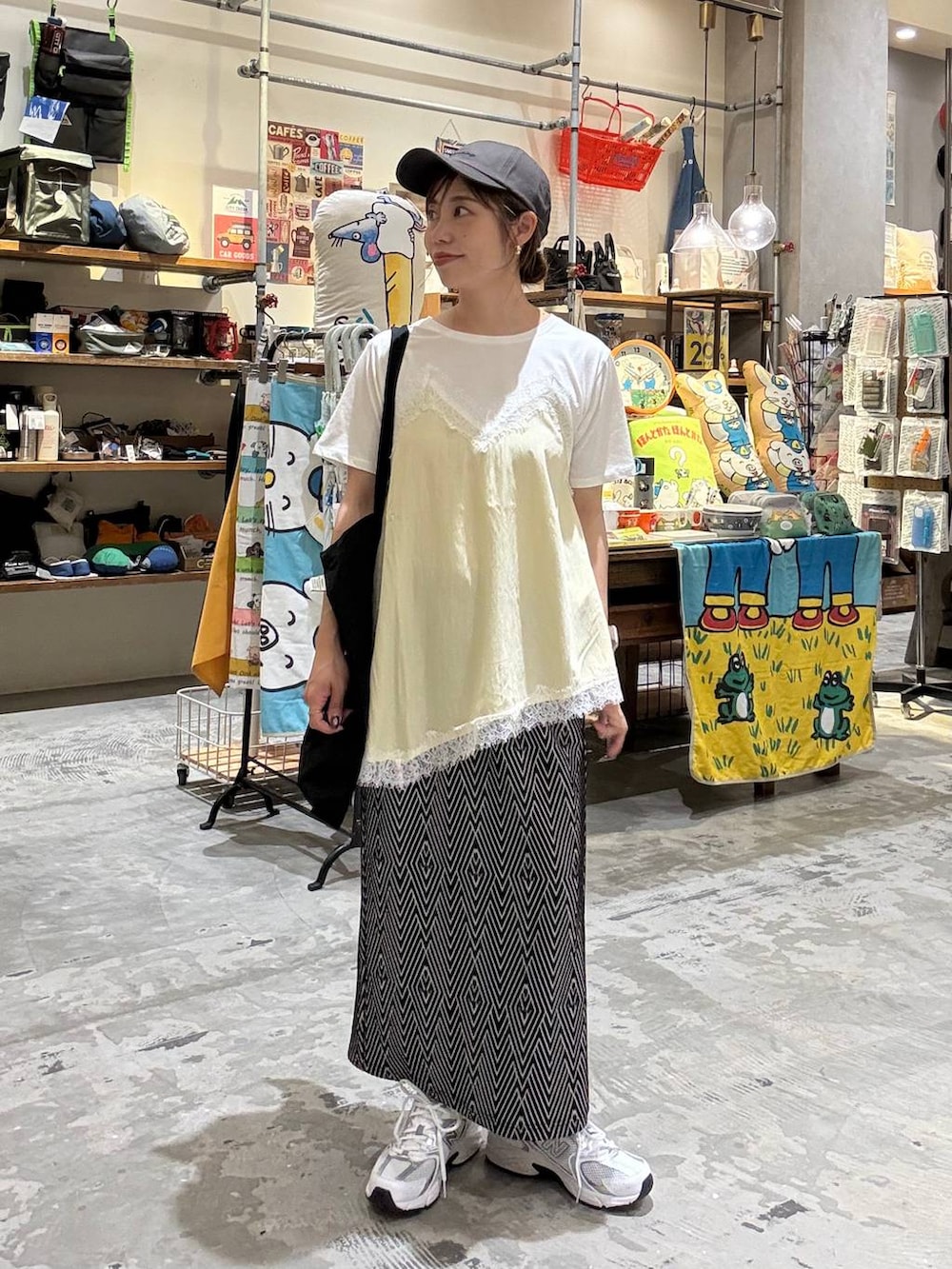 ブラック系のトートバッグ、ブラック系のスカート、ベージュ系のTシャツ/カットソーを着用したレディースの春コーディネートの6枚目の写真