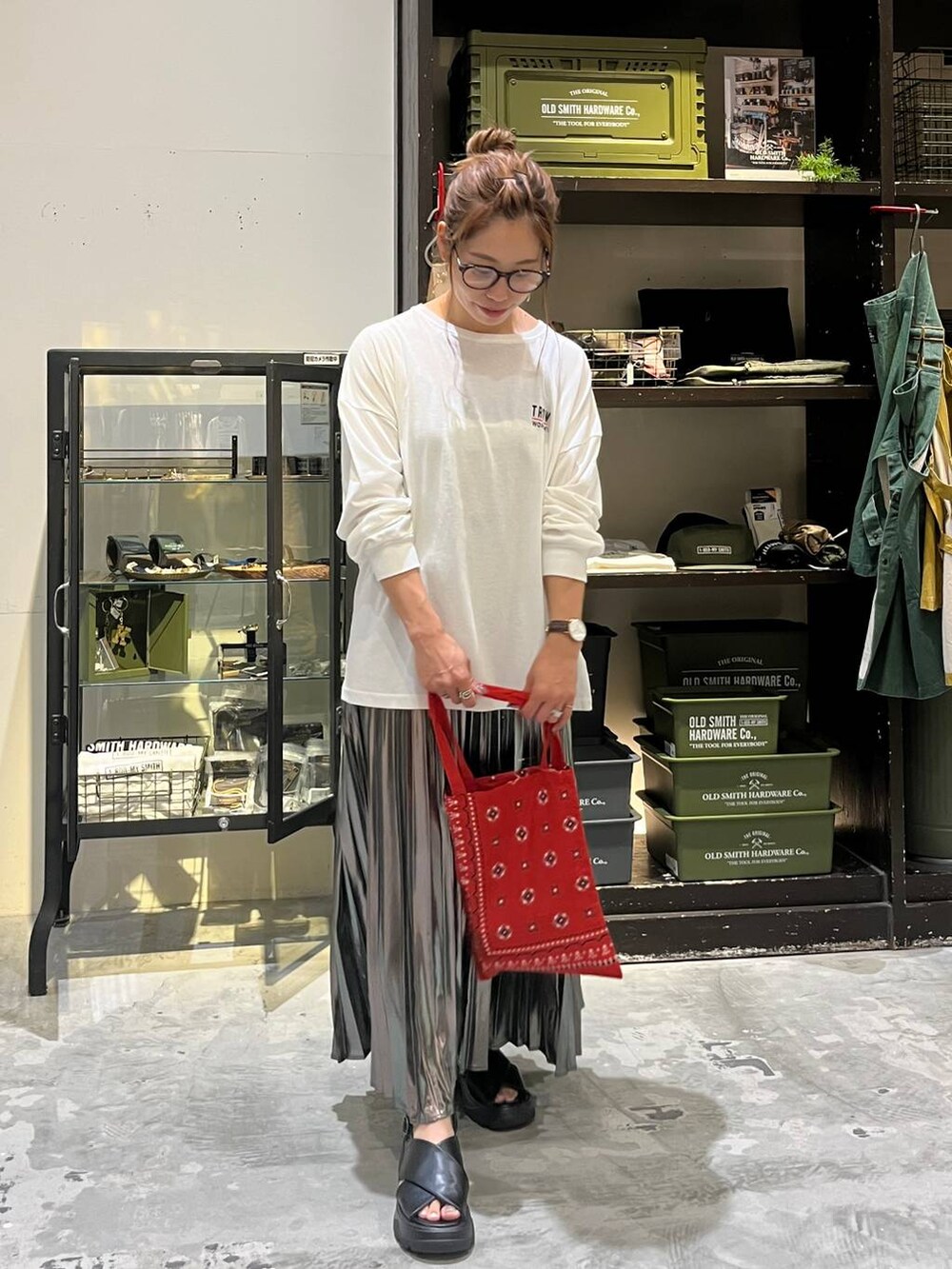 ブラック系のサンダル、ホワイト系のTシャツ/カットソー、レッド系のトートバッグを着用したレディースの夏コーディネートの4枚目の写真