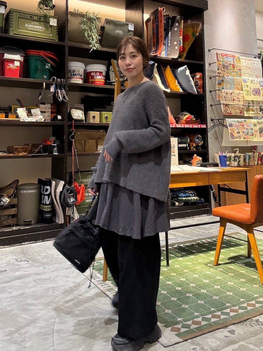 グレー系のニット/セーター、ブラック系のデニムパンツ、ブラック系のその他パンツを着用したレディースの冬コーディネートの6枚目の写真