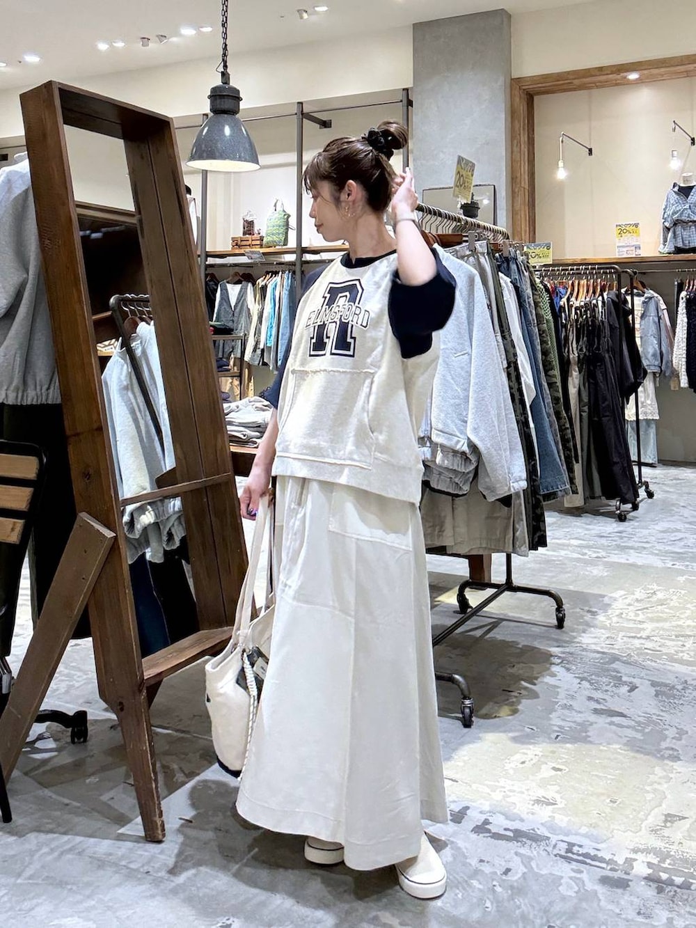 ベージュ系のトートバッグ、ベージュ系のTシャツ/カットソー、ベージュ系のスカートを着用したレディースの春コーディネートの4枚目の写真