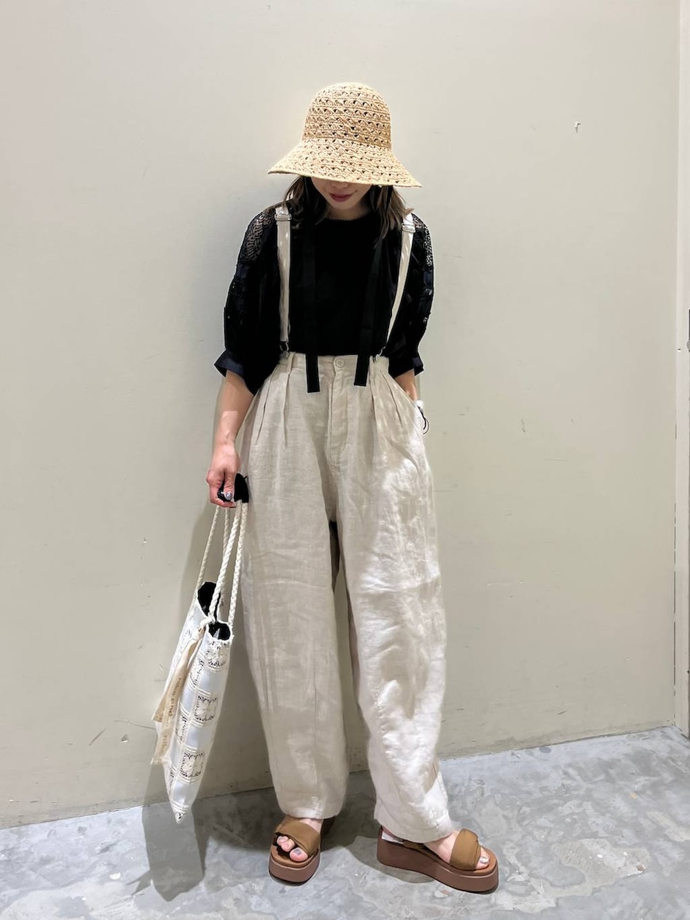 イエロー系のサンダル、ベージュ系のその他パンツ、ホワイト系のトートバッグを着用したレディースの春コーディネートの2枚目の写真