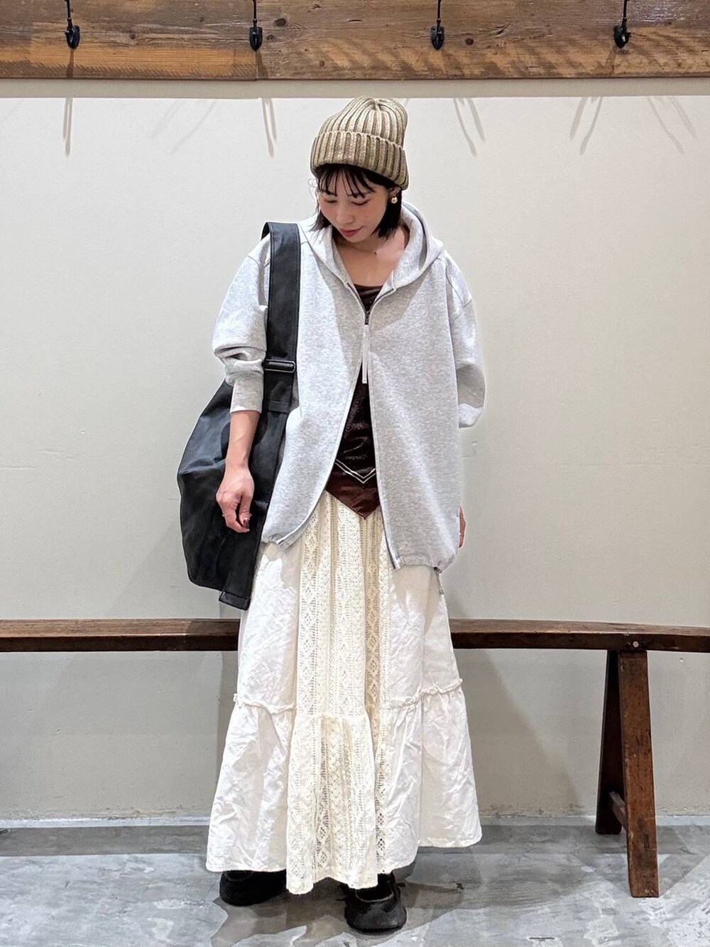 ベージュ系のスカート、ブラック系のショルダーバッグ、グレー系のパーカーを着用したレディースの秋コーディネートの5枚目の写真