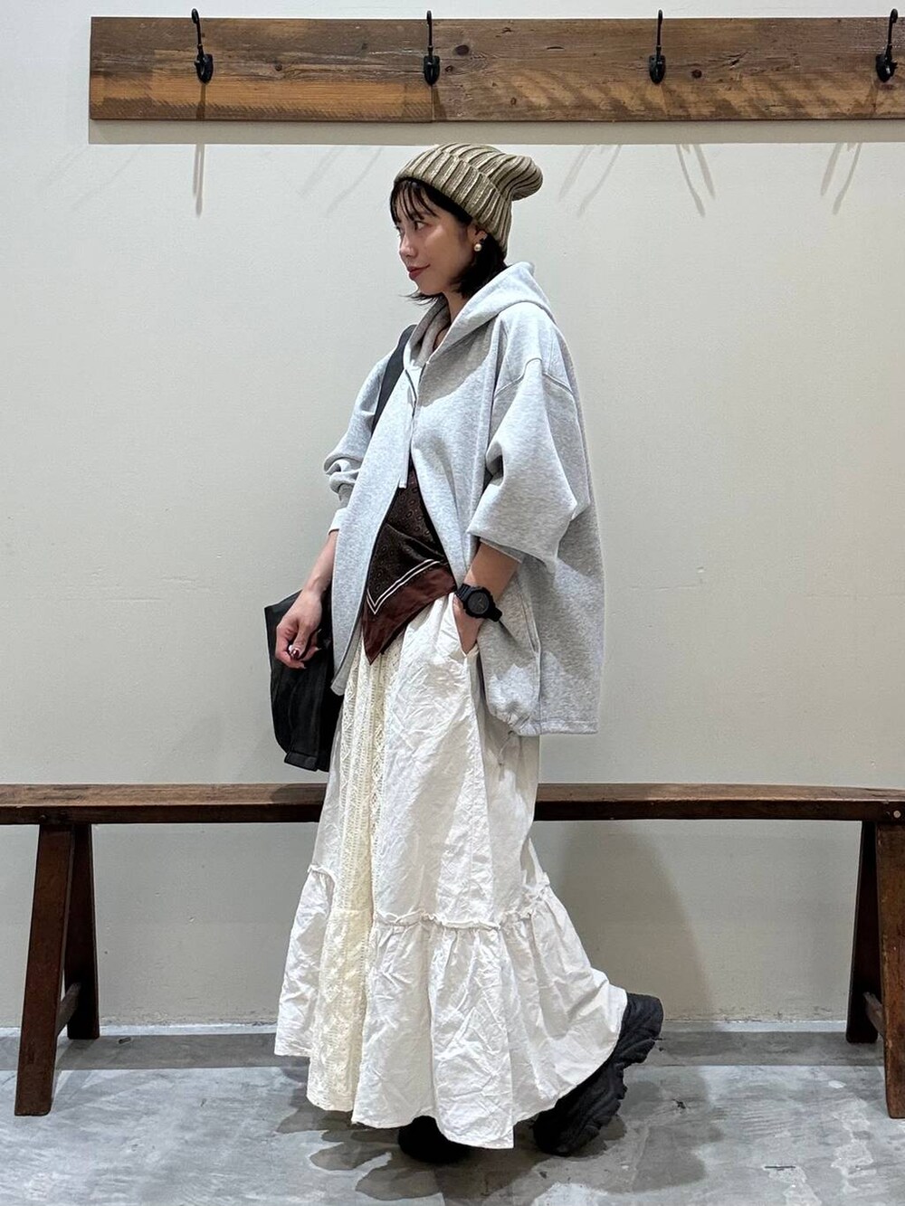 ベージュ系のスカート、ブラック系のショルダーバッグ、グレー系のパーカーを着用したレディースの秋コーディネートの7枚目の写真