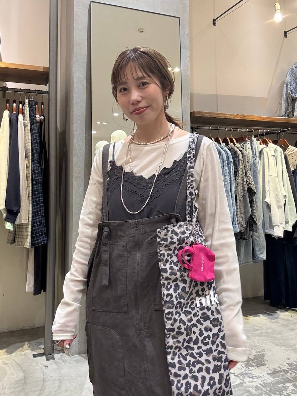 その他のトートバッグ、ゴールド系のスニーカー、グレー系のワンピースを着用したレディースの春コーディネートの3枚目の写真