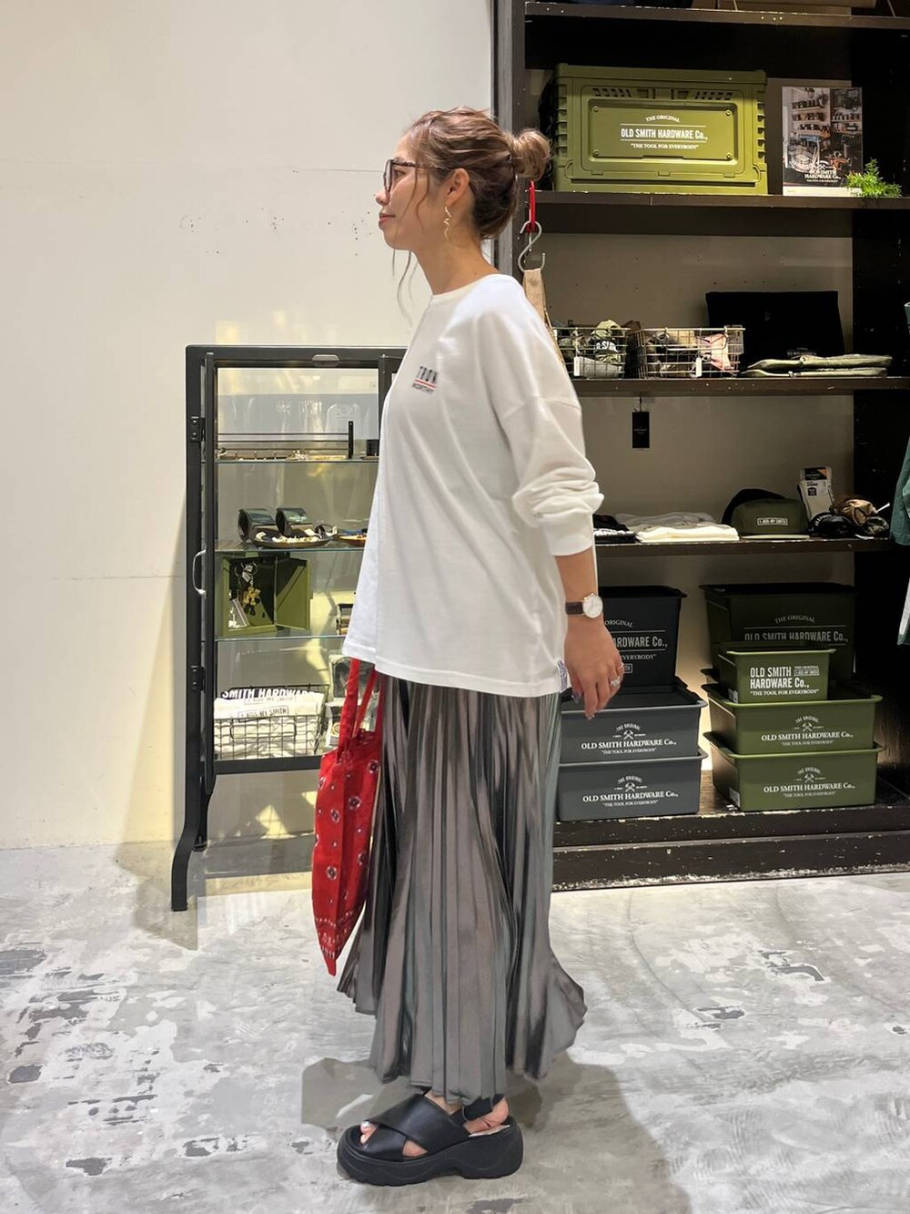 ブラック系のサンダル、ホワイト系のTシャツ/カットソー、レッド系のトートバッグを着用したレディースの夏コーディネートの7枚目の写真