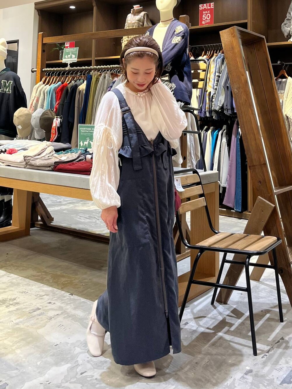 グレー系のジャンパースカート、ホワイト系のパンプス、ホワイト系のシャツ/ブラウスを着用したレディースの冬コーディネートの3枚目の写真