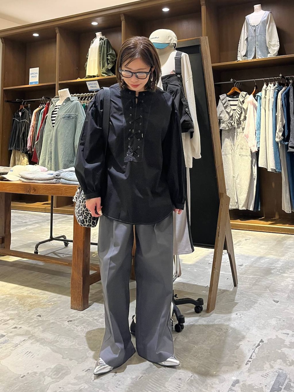 グレー系のサンダル、ブラック系のシャツ/ブラウス、その他のショルダーバッグを着用したレディースの春コーディネートの2枚目の写真