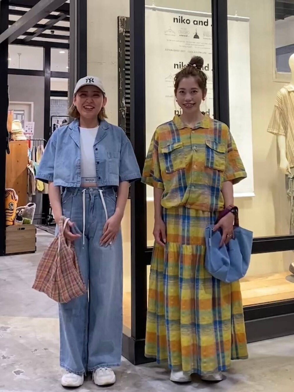 ブルー系のトートバッグ、グレー系のタンクトップ、ブラック系のスニーカーを着用したレディースの春コーディネートの3枚目の写真