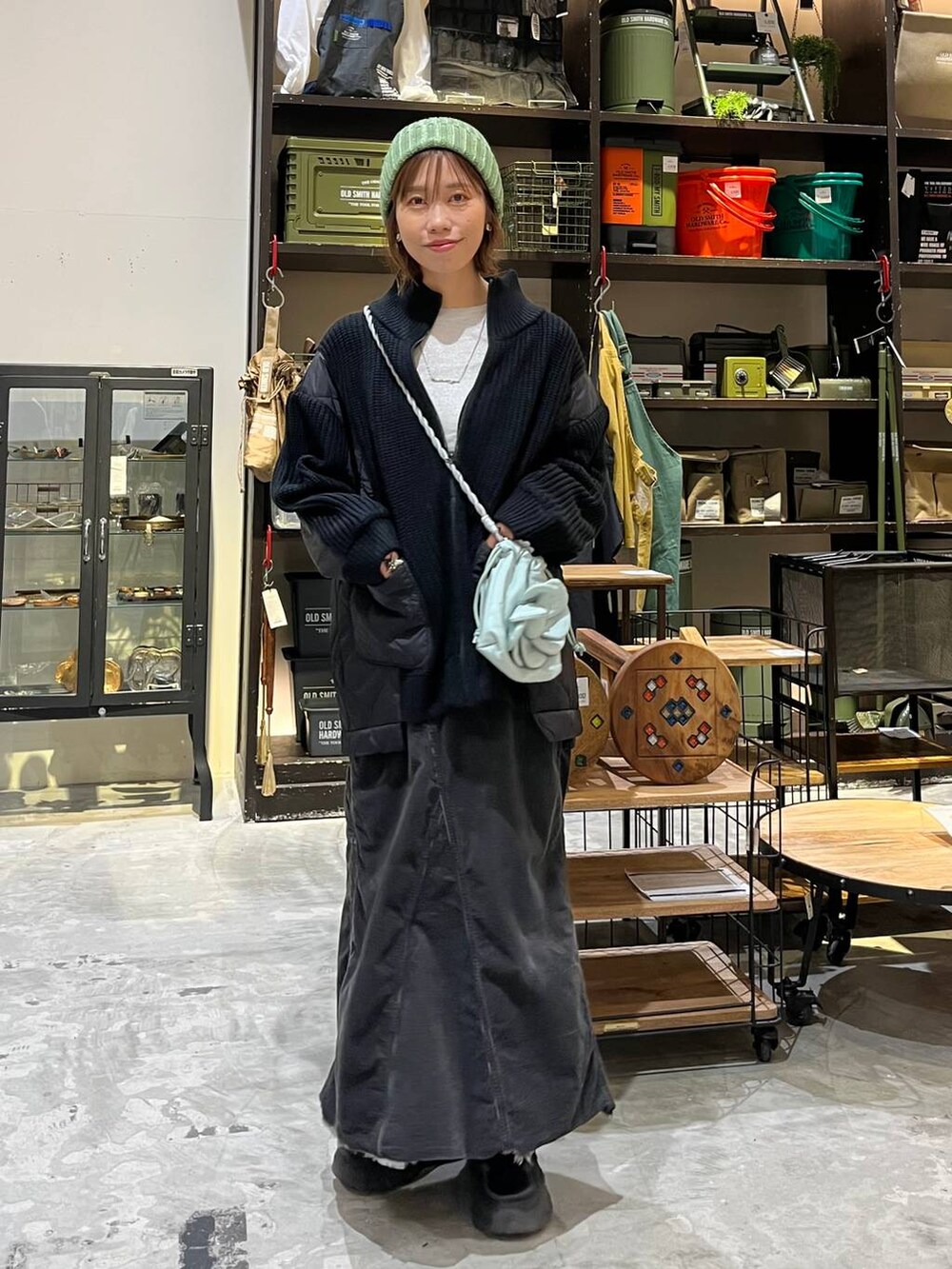 グレー系のスカート、グレー系のTシャツ/カットソー、ブラック系のブルゾンを着用したレディースの冬コーディネートの3枚目の写真