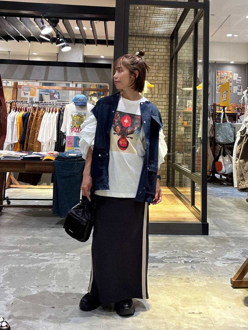ホワイト系のスカート、ブラック系のスニーカー、ホワイト系のTシャツ/カットソーを着用したレディースの夏コーディネートの5枚目の写真