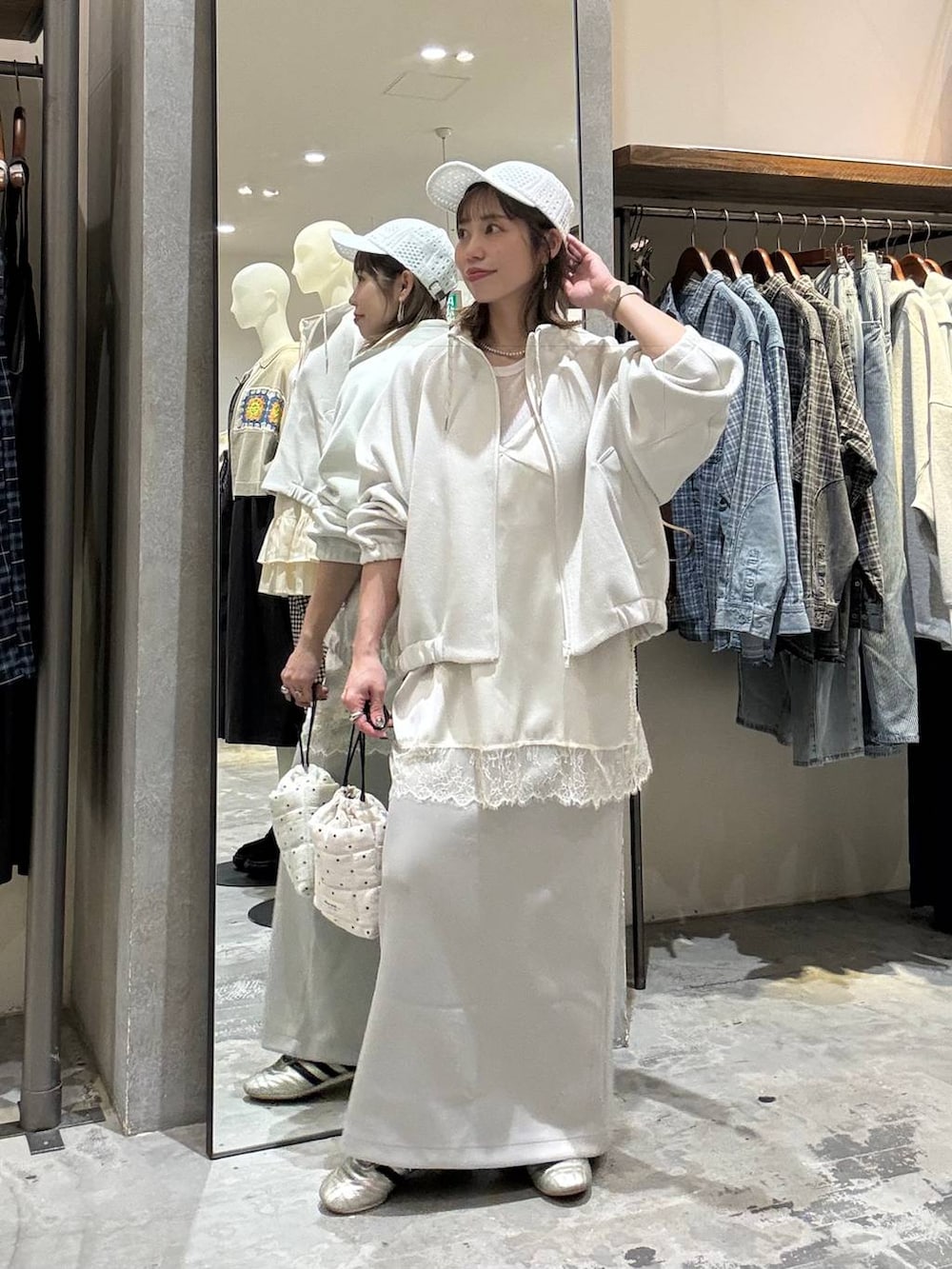 ゴールド系のスニーカー、ホワイト系のショルダーバッグ、ベージュ系のブルゾンを着用したレディースの春コーディネートの4枚目の写真