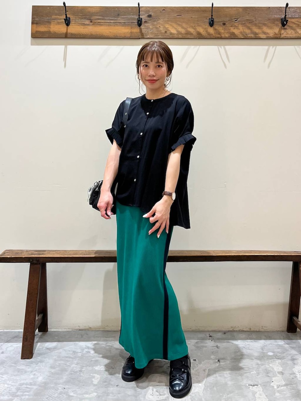 グリーン系のスカート、ブラック系のショルダーバッグ、ブラック系のバレエシューズを着用したレディースの春コーディネートの5枚目の写真
