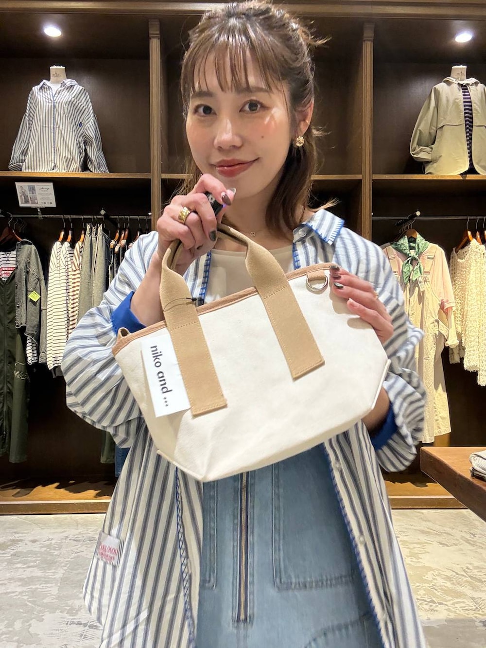 ブルー系のジャンパースカート、ベージュ系のTシャツ/カットソー、その他のショルダーバッグを着用したレディースの春コーディネートの7枚目の写真