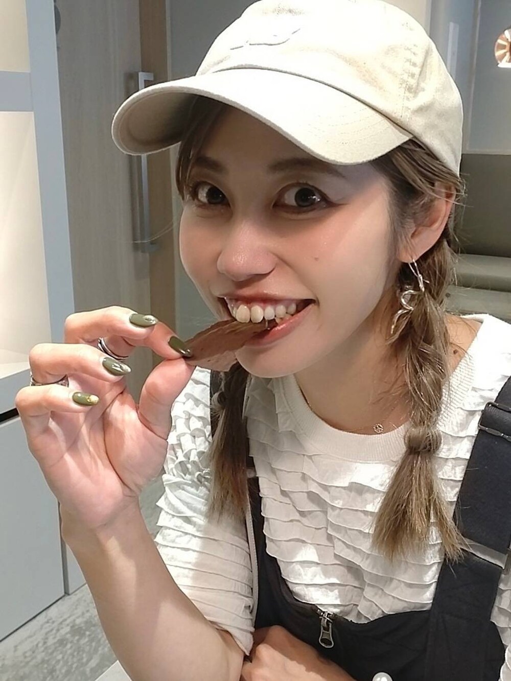 ベージュ系のキャップを着用したレディースの夏コーディネートの3枚目の写真