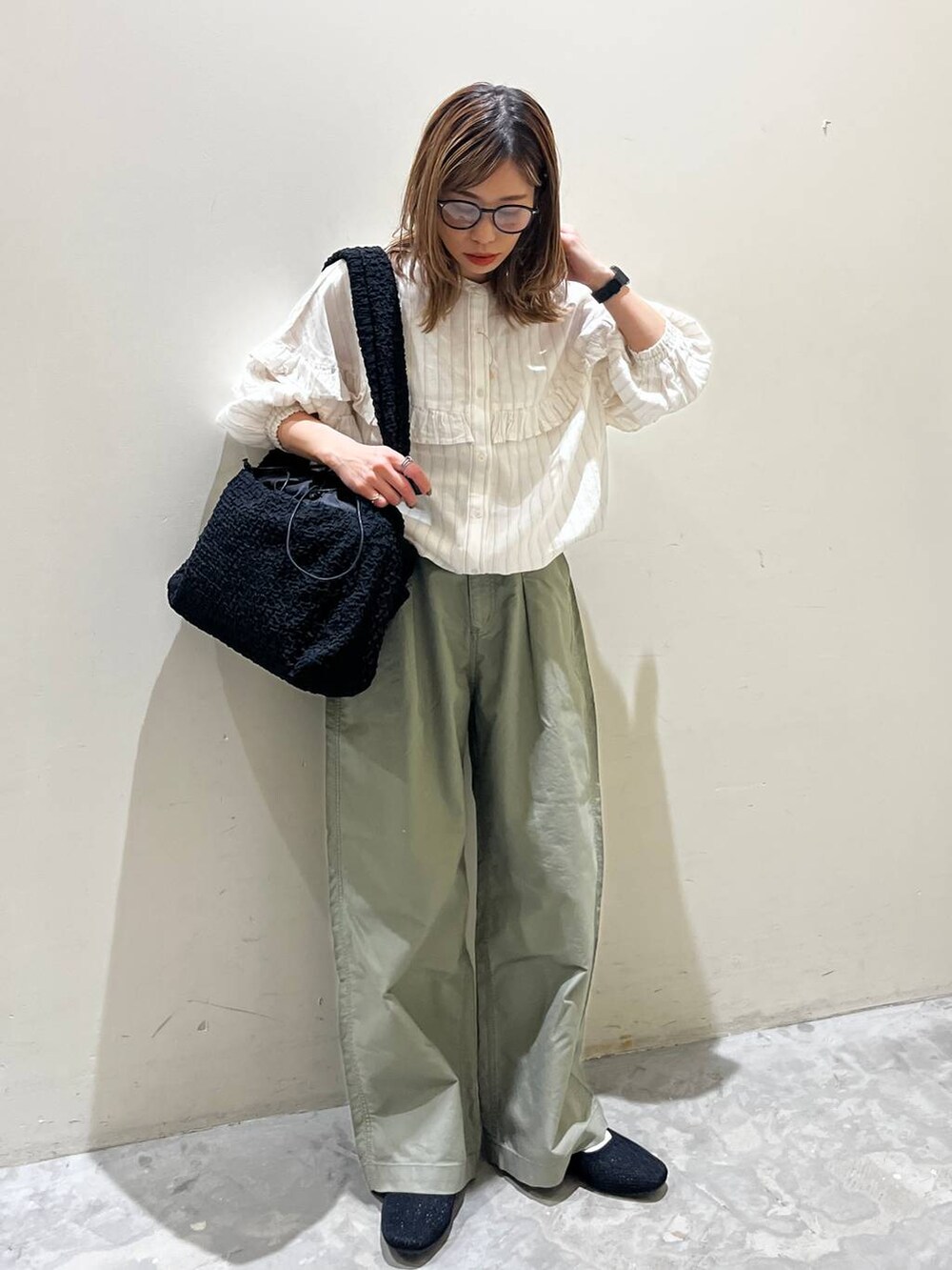 ブラック系のショルダーバッグ、ブラック系のその他シューズ、ベージュ系のシャツ/ブラウスを着用したレディースの春コーディネートの9枚目の写真