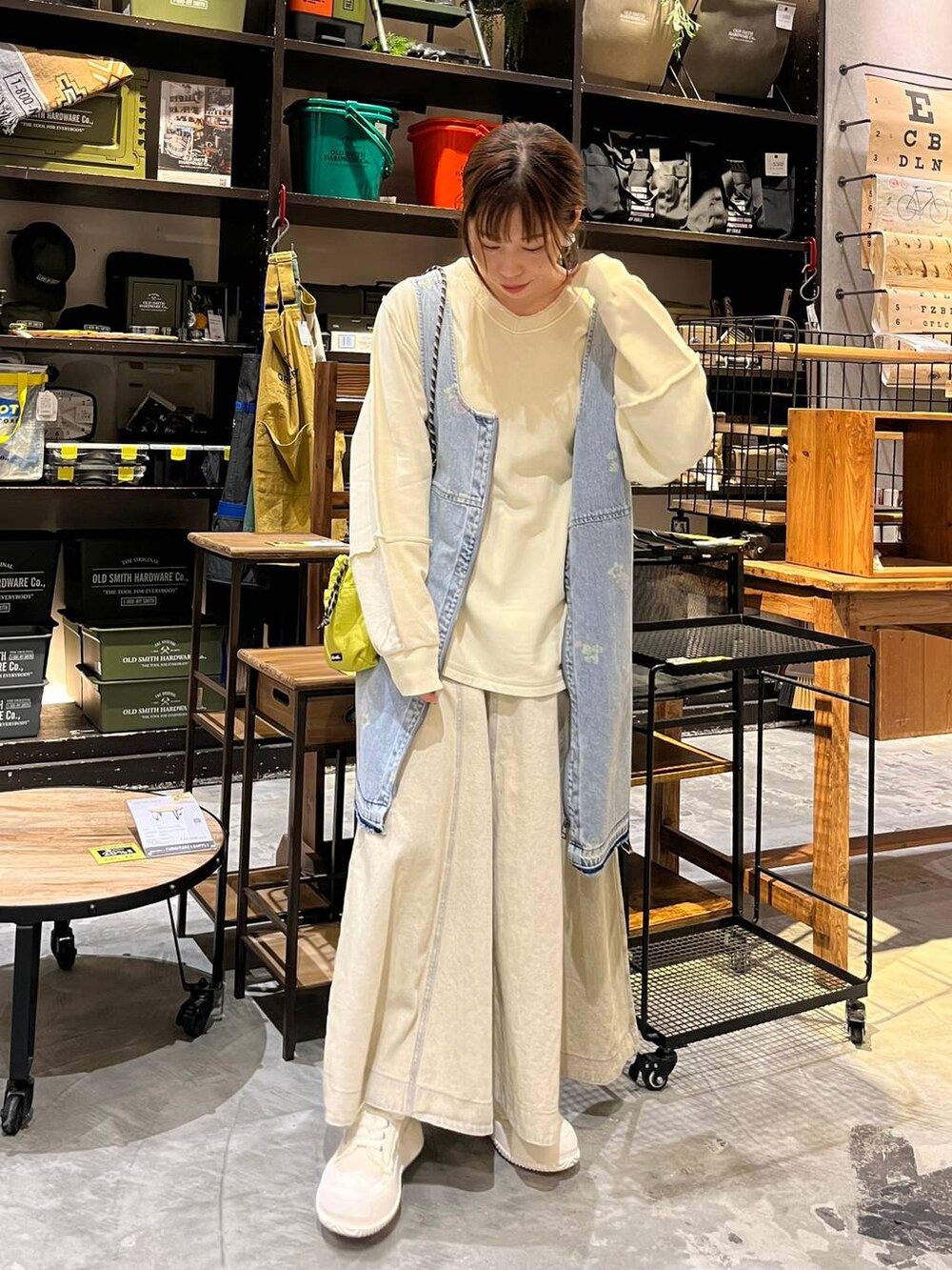 イエロー系のショルダーバッグ、ブルー系のドレス、ベージュ系のスニーカーを着用したレディースの冬コーディネートの5枚目の写真