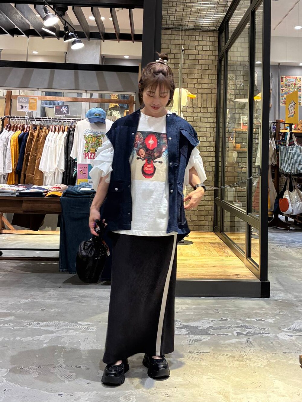 ホワイト系のスカート、ブラック系のスニーカー、ホワイト系のTシャツ/カットソーを着用したレディースの夏コーディネートの2枚目の写真