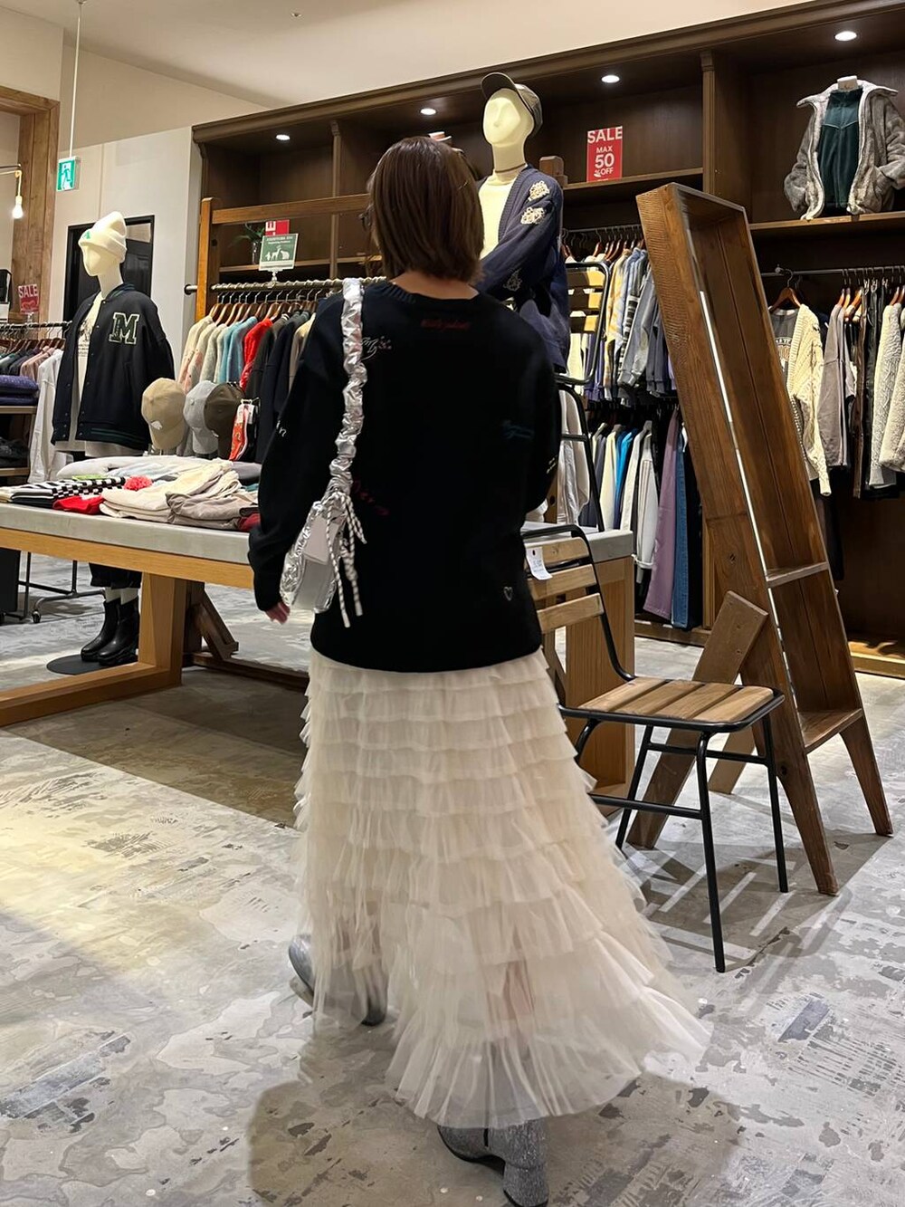 グレー系のブーツ、ホワイト系のスカート、シルバー系のショルダーバッグを着用したレディースの冬コーディネートの8枚目の写真