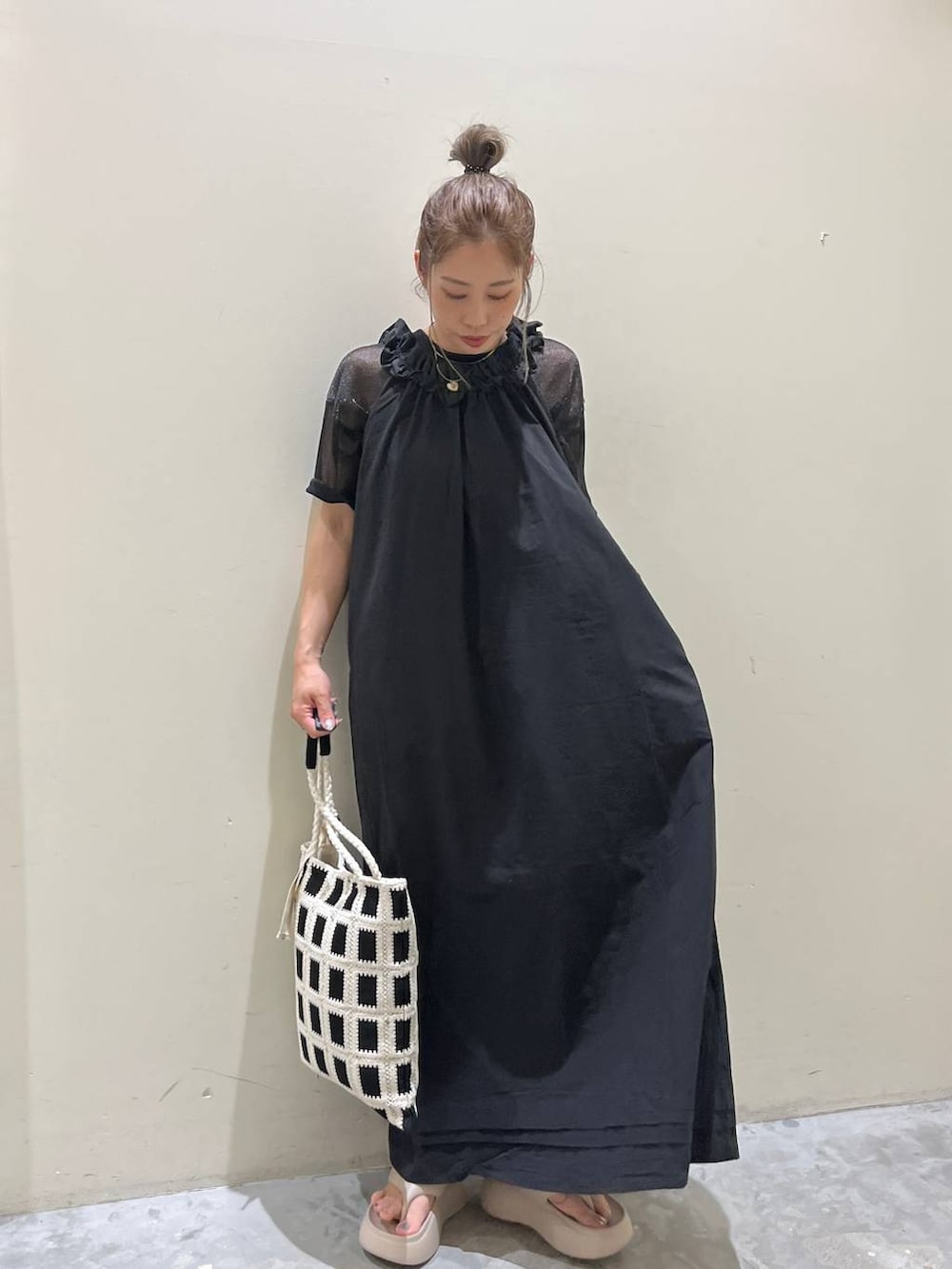 ベージュ系のサンダル、ブラック系のワンピース、ブラック系のトートバッグを着用したレディースの春コーディネートの5枚目の写真