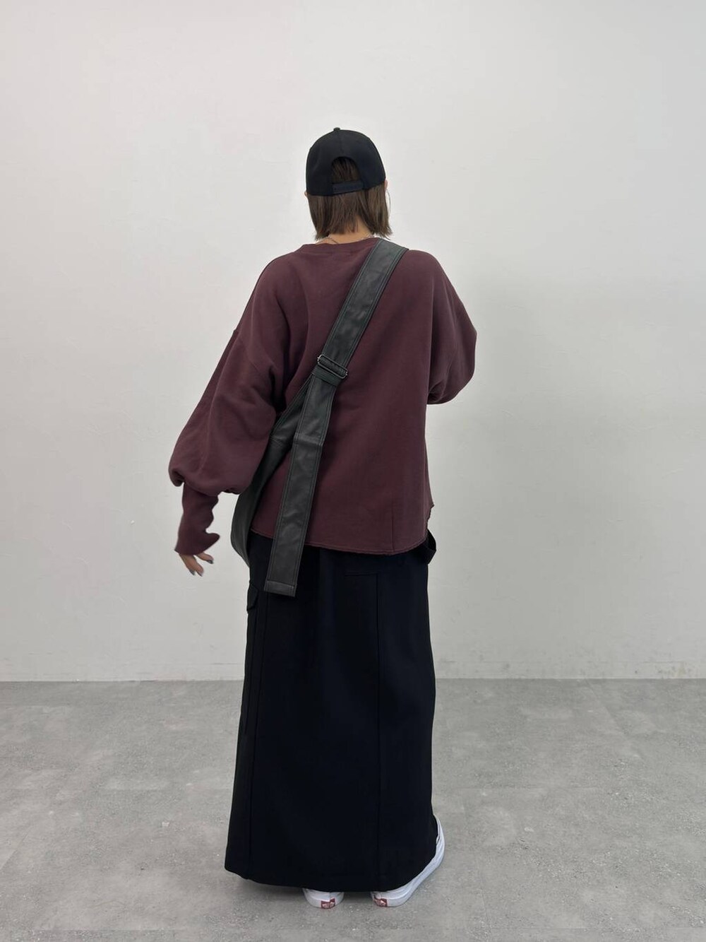 ブラック系のスカート、ブラック系のショルダーバッグ、レッド系のスウェットを着用したレディースの夏コーディネートの5枚目の写真