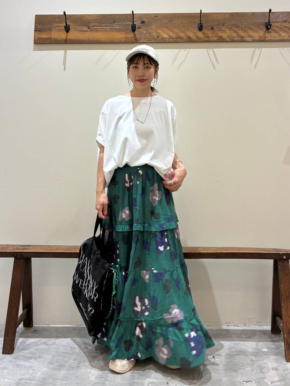 ブラック系のトートバッグ、グリーン系のスカート、ベージュ系のサンダルを着用したレディースの夏コーディネートの8枚目の写真