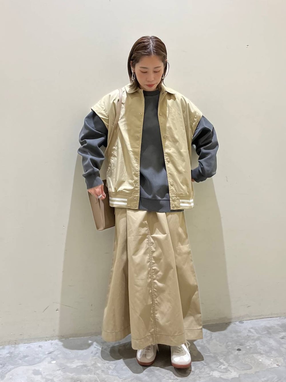 ベージュ系のスニーカー、ベージュ系のスタジャン、ベージュ系のスカートを着用したレディースの冬コーディネートの2枚目の写真