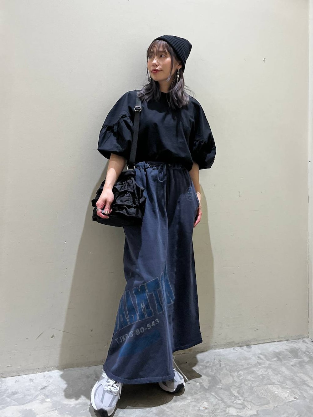 ブラック系のショルダーバッグ、ブルー系のスカート、ブラック系のシャツ/ブラウスを着用したレディースの春コーディネートの6枚目の写真