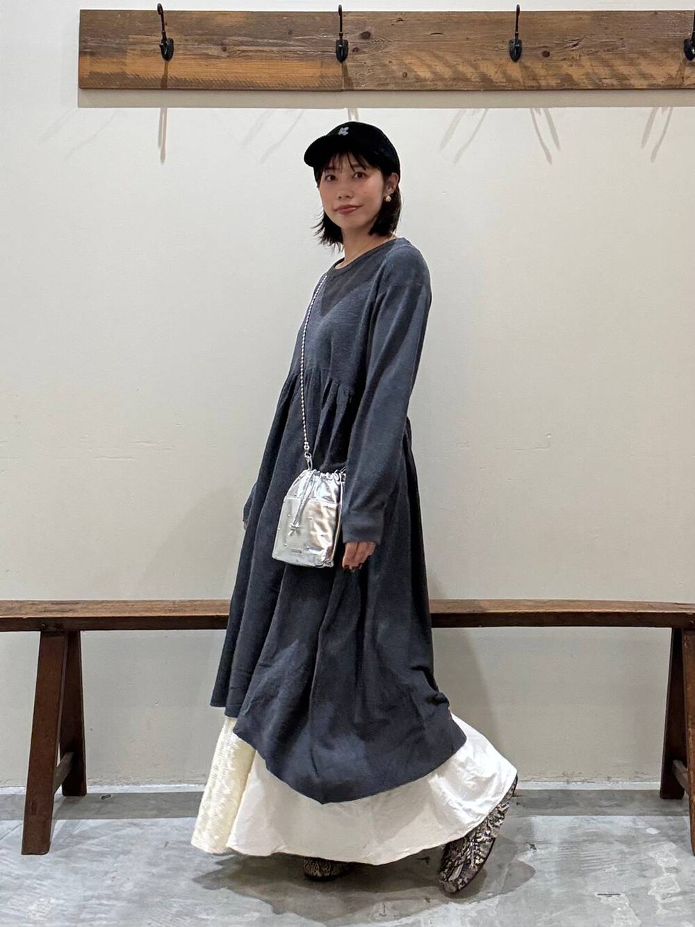 シルバー系のショルダーバッグ、グレー系のワンピース、ベージュ系のスカートを着用したレディースの秋コーディネートの5枚目の写真