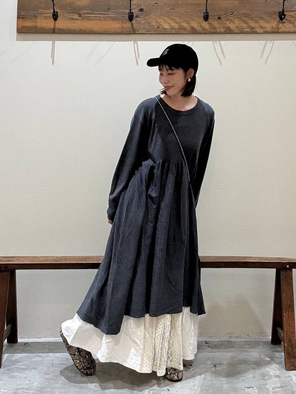 シルバー系のショルダーバッグ、グレー系のワンピース、ベージュ系のスカートを着用したレディースの秋コーディネートの2枚目の写真