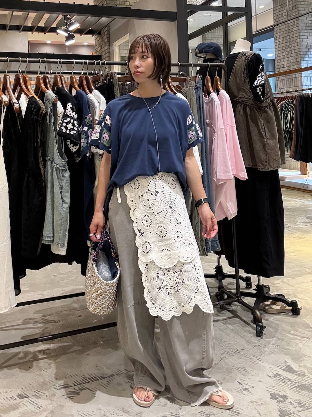 グレー系のその他パンツ、ベージュ系のサンダル、グレー系のかごバッグを着用したレディースの夏コーディネートの2枚目の写真