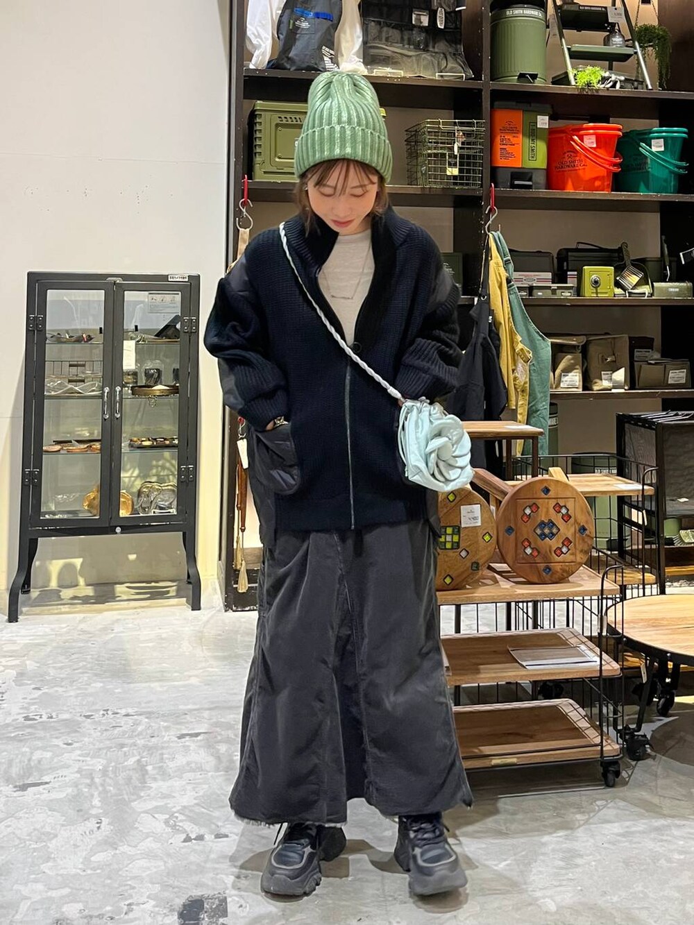 グレー系のスカート、グレー系のTシャツ/カットソー、ブラック系のブルゾンを着用したレディースの冬コーディネートの6枚目の写真