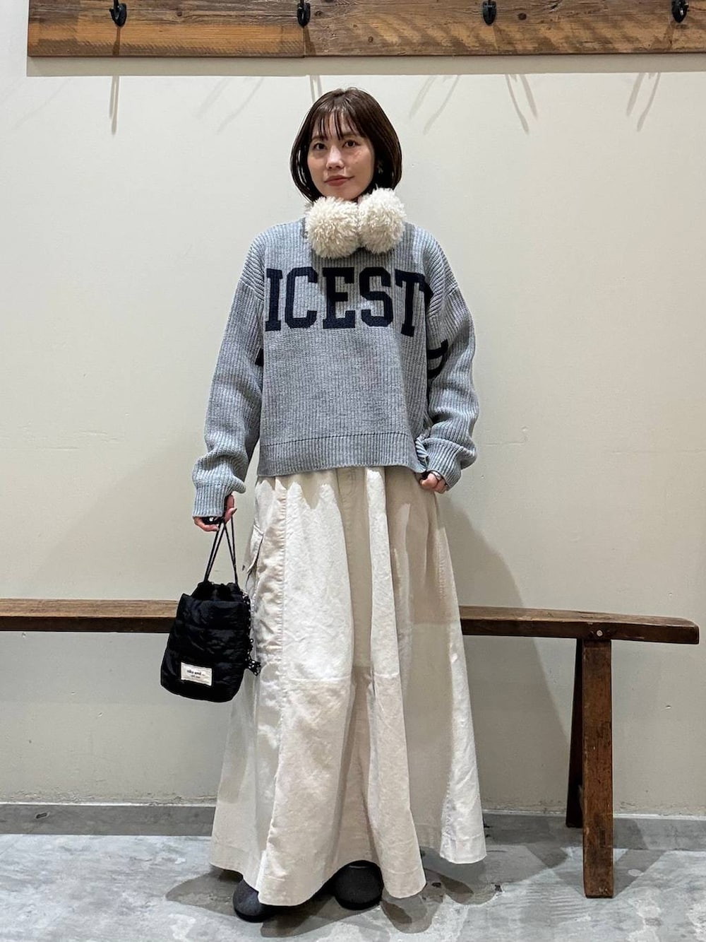 ベージュ系のスカート、ブラック系のショルダーバッグ、グレー系のパンプスを着用したレディースの冬コーディネートの3枚目の写真